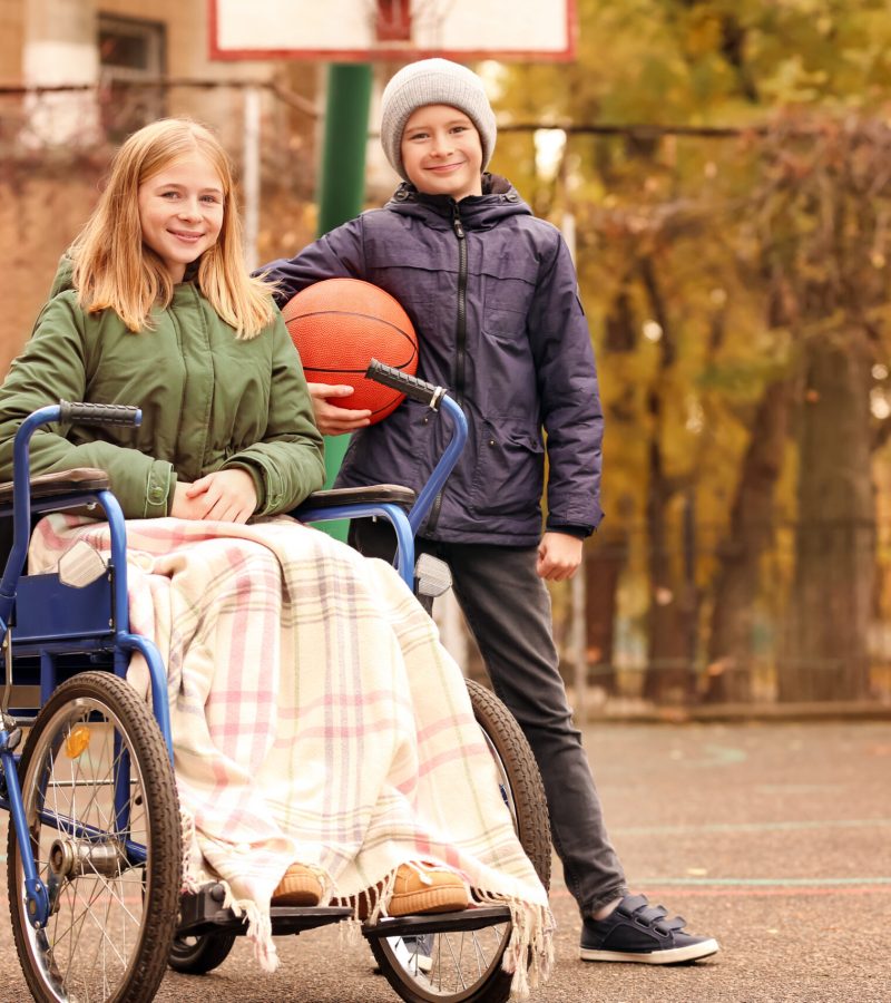Little,Girl,In,Wheelchair,And,Her,Brother,With,Ball,On